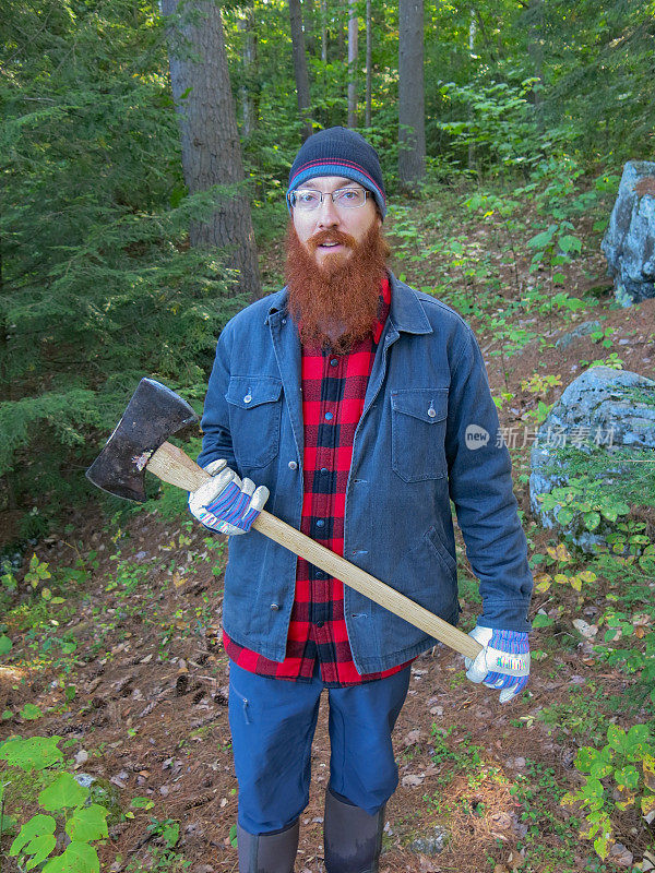 Lumbersexual Redhead Hipster Camping Man Holding Axe in Woods